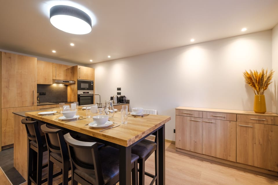 The modern kitchen is fully equipped with sleek cabinetry and appliances, making it easy to prepare meals for the whole group.