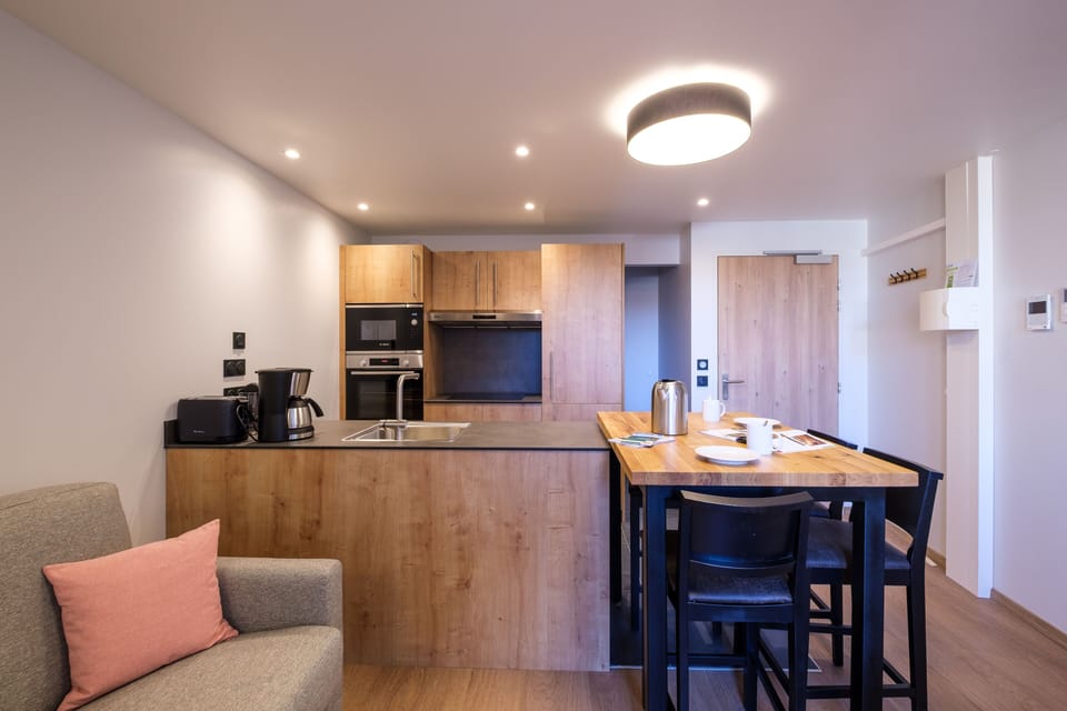 The fully equipped kitchen features modern appliances and generous counter space, making meal preparation easy and enjoyable.