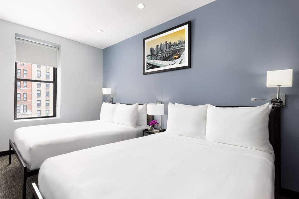 Stretch out on plush beds in a calm, modern room.