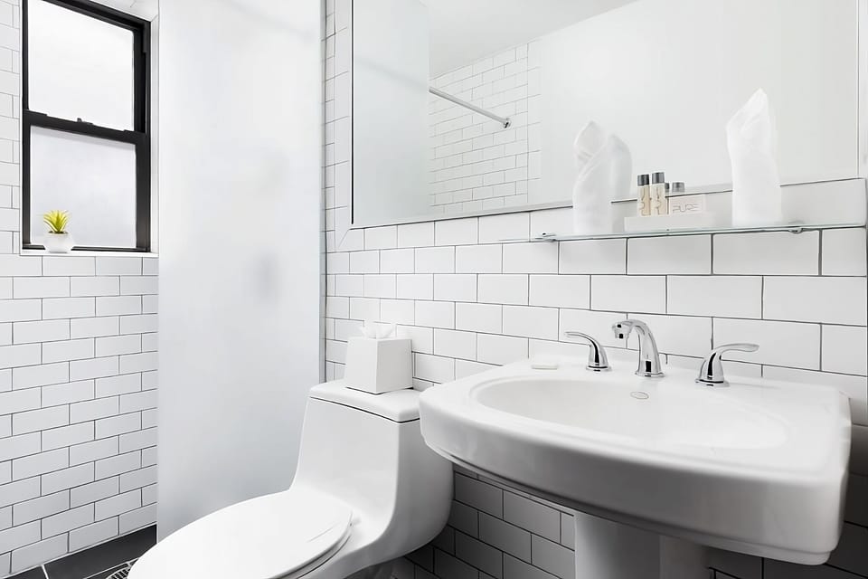 Refresh comfortably in a spotless, bright bathroom with ample mirror.