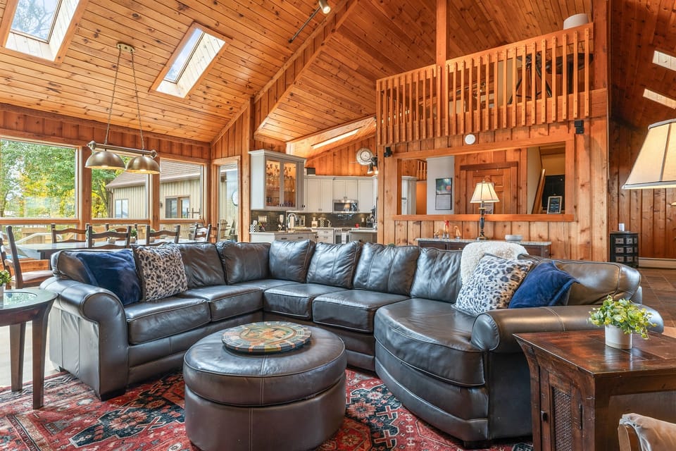 Inviting family room with wrap-around sofa and high wood ceilings — a relaxing hub for game nights and movie marathons