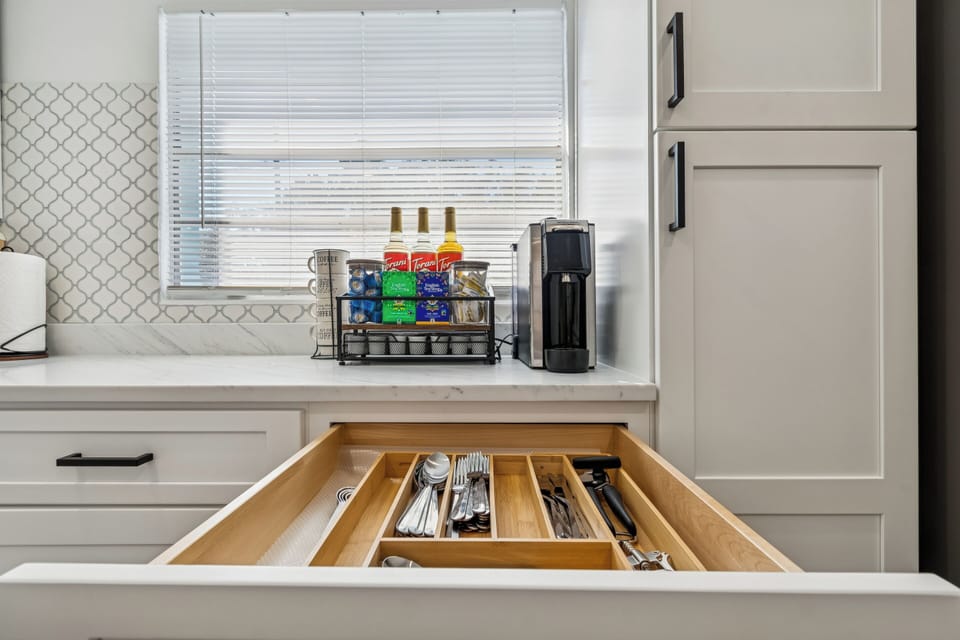 Coffee station with coffee maker, coffee capsules, syrup, creamer, tea and cups for a refreshing start.