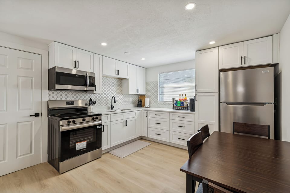 Fully equipped kitchen with two door refrigerator, stove/oven, sink and modern kitchen cabinets.
