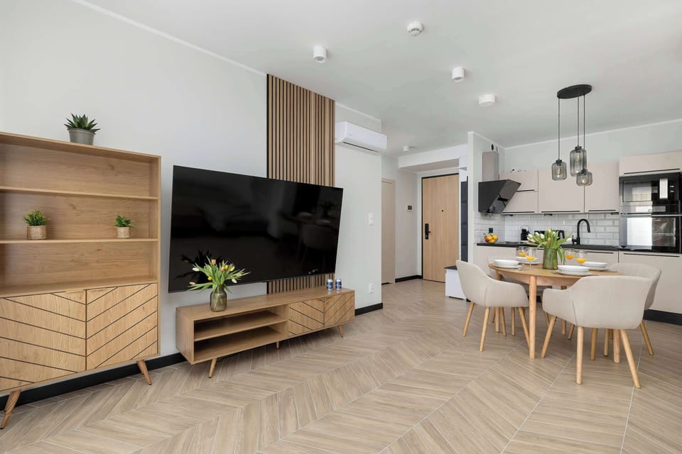 A wooden media console with a television and matching shelving unit, showcasing a clean and modern interior design.