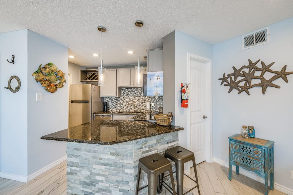 Your coastal-themed kitchen awaits with granite counters, modern appliances, and charming breakfast bar—perfect for morning coffee or evening cocktails.