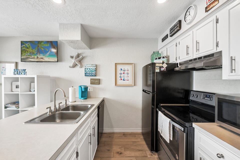 Your bright, beach-themed kitchen awaits with everything you need—full appliances, coffee maker, and charming coastal decor to inspire your culinary adventures.