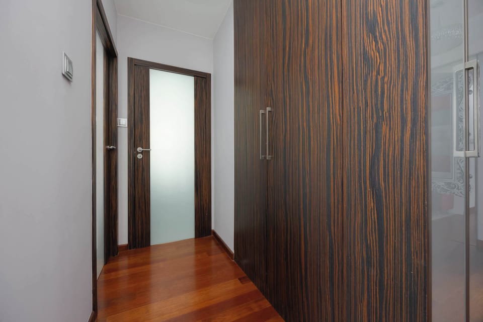 A hallway with wooden flooring and modern doors. The walls have subtle decorative patterns for added texture.