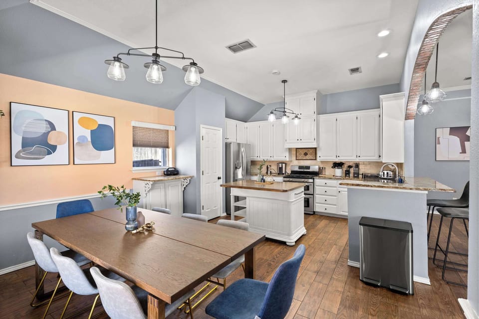 Bright, open-concept kitchen and dining with modern finishes, stylish lighting, and a spacious island—perfect for gathering and entertaining.