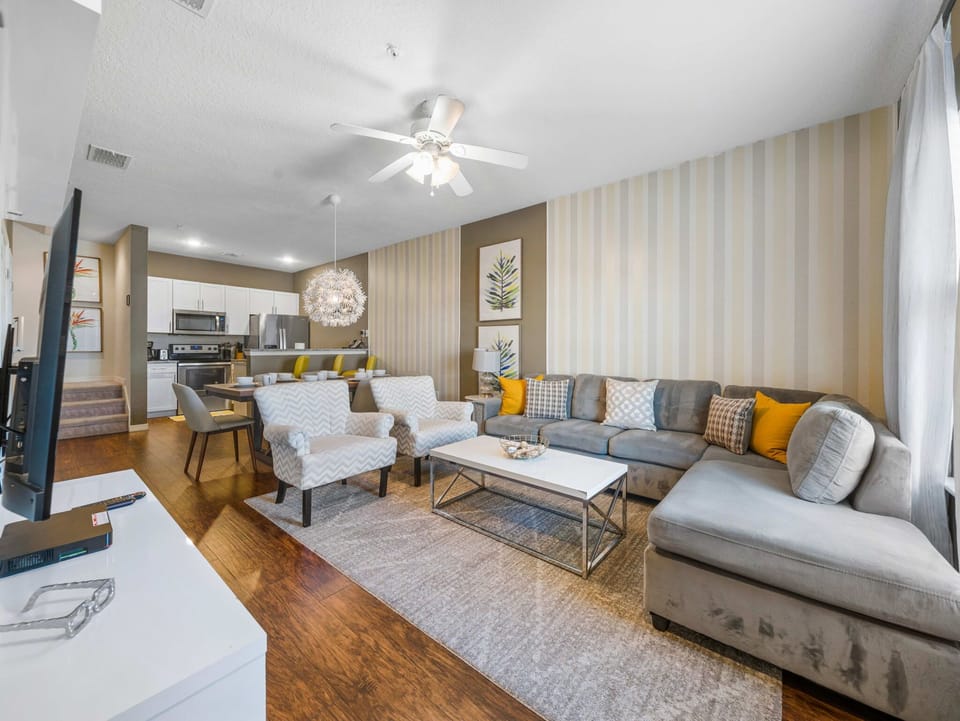 Modern living room with a large sectional sofa and open kitchen in the background