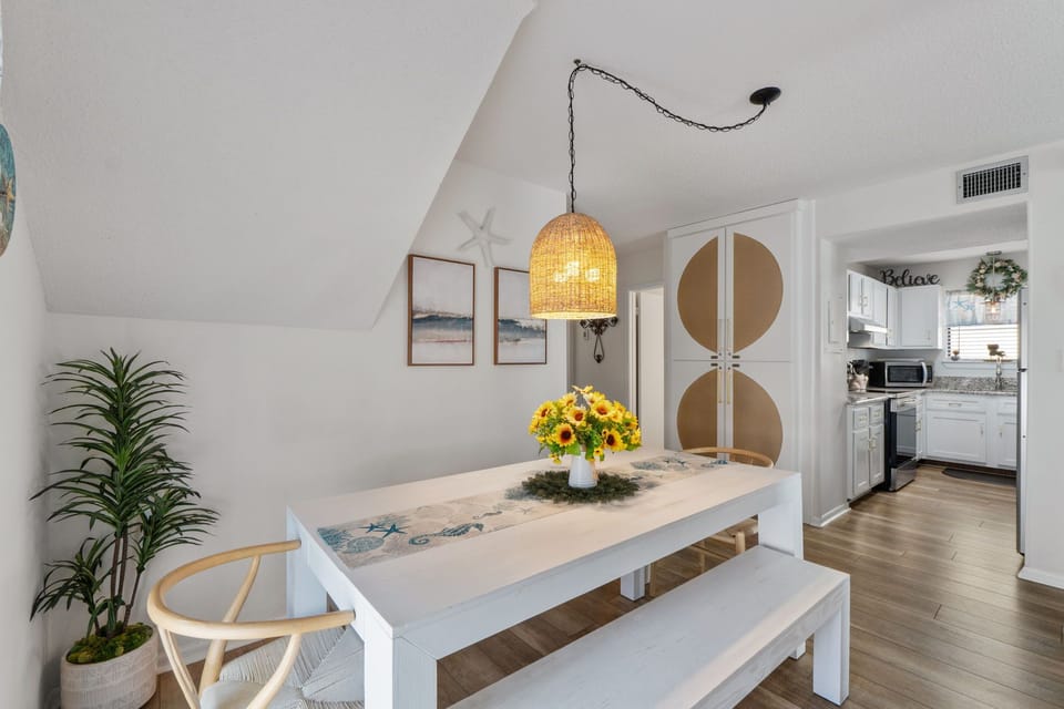 Gather around your bright dining space where sunflowers and coastal charm create the perfect setting for memorable meals together.