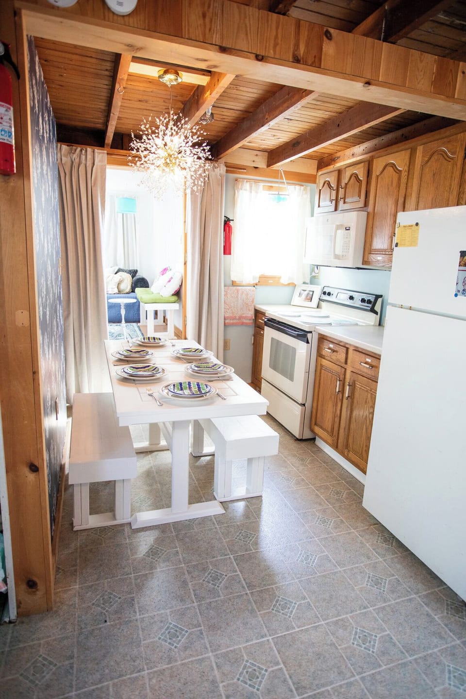 Kitchen and dining with pine beams, oak cabinets, and a table ready for vacation meals.
