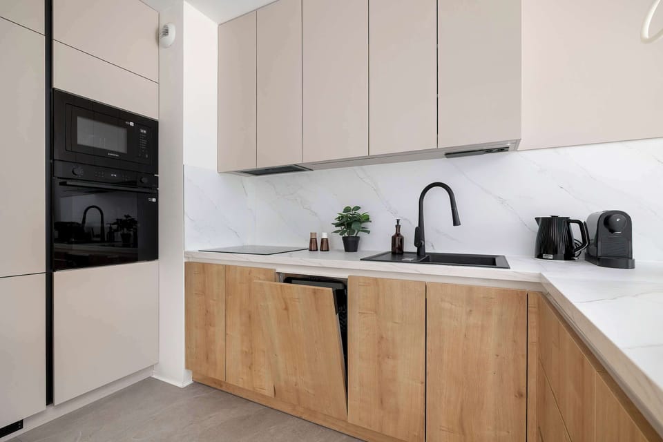 Fully equipped kitchen with modern cabinetry, oven, dishwasher and generous workspace.
