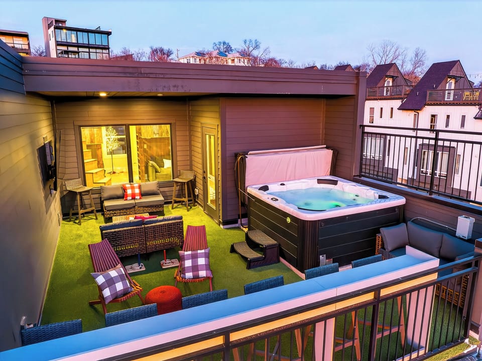 Rooftop oasis at golden hour—hot tub, lounge seating & city vibes.