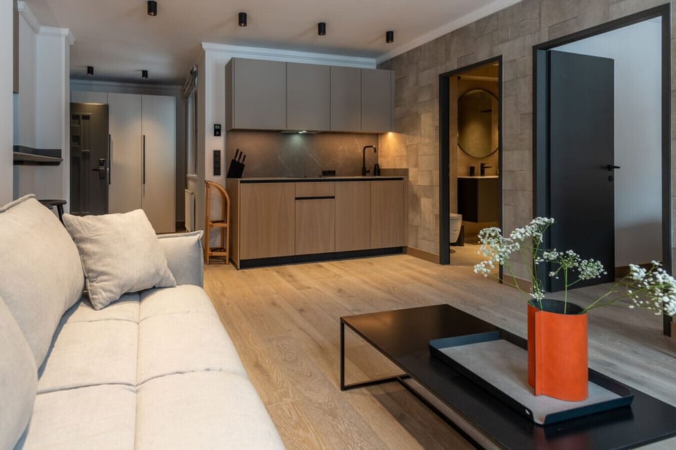 Wohnzimmer mit Sofa, TV und Pflanzen.