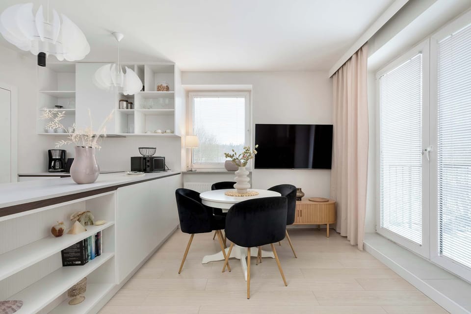 Open living space connecting the kitchenette and relaxation area in a bright, airy setting.