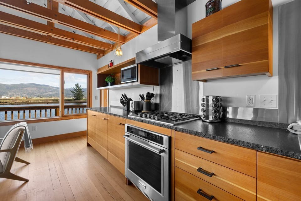 Cook with mountain views in this stunning modern kitchen featuring warm wood cabinetry, granite counters, and professional appliances.