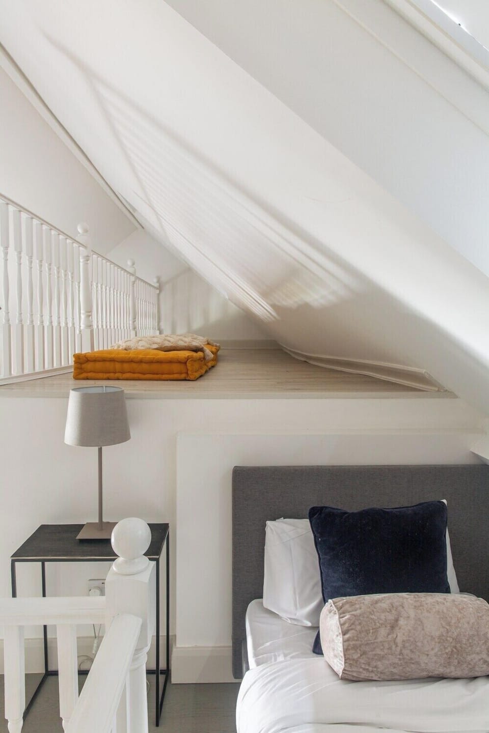 Single bed in mezzanine level of living room 