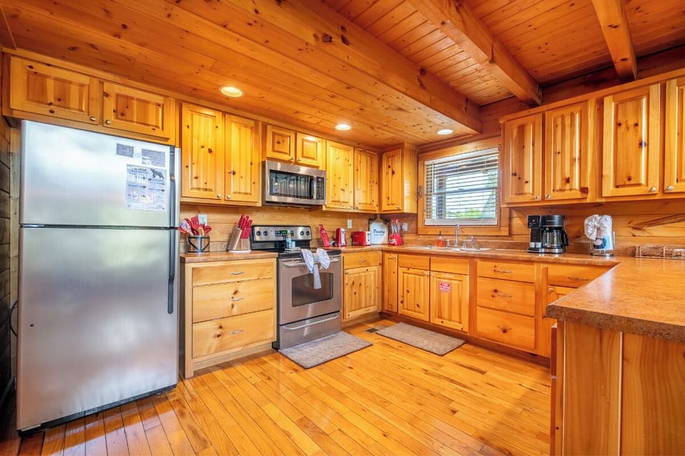 Your fully equipped kitchen features warm wood cabinetry, stainless steel appliances, and plenty of counter space for preparing meals together.