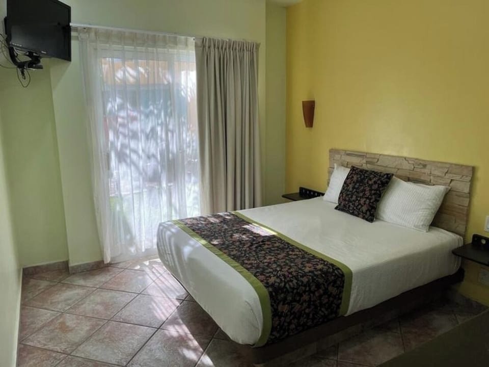 Unwind in a sunlit king bed with breezy curtains.