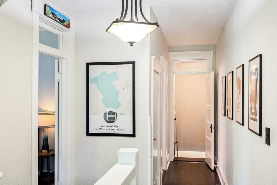 Welcome to the adventure level. The upper-floor hallway features custom local maps and vintage travel-inspired decor connecting the upper bedrooms.