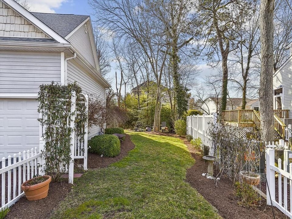 A beautifully landscaped side yard enhances the home’s coastal charm with space for outdoor fun and family gatherings.