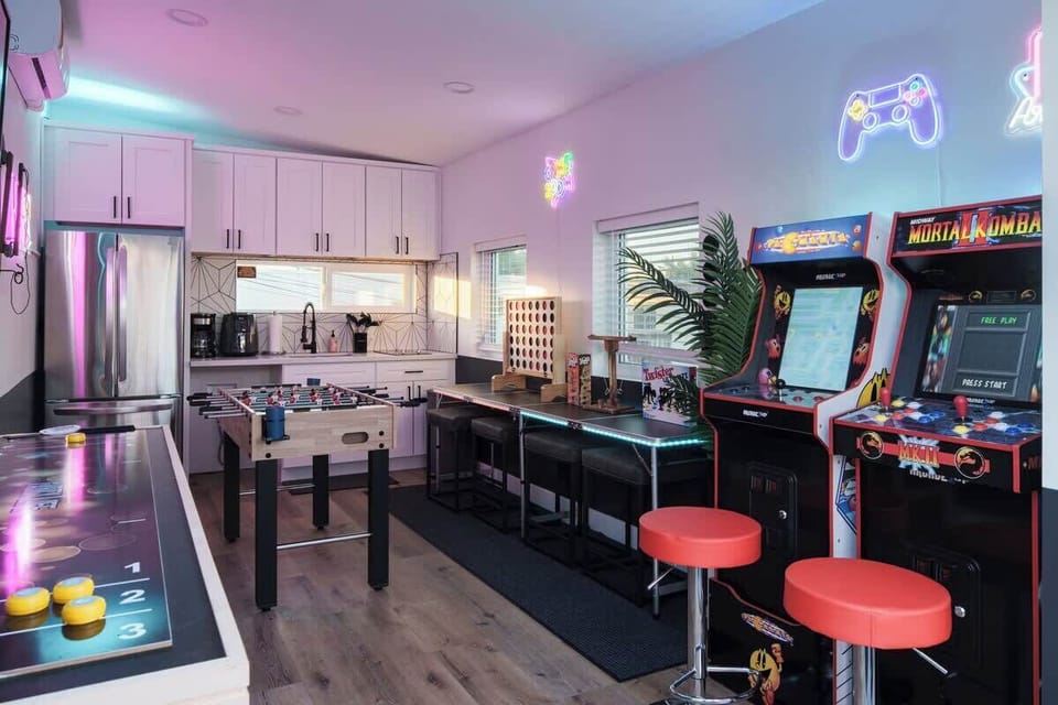 Open entertainment area with arcade machines, bar stools and wide pathways for social hangouts and parties