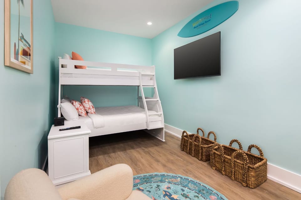 A playful bunk room adorned with vibrant decor and beach-themed accents, perfect for family fun and relaxation by the Gulf.