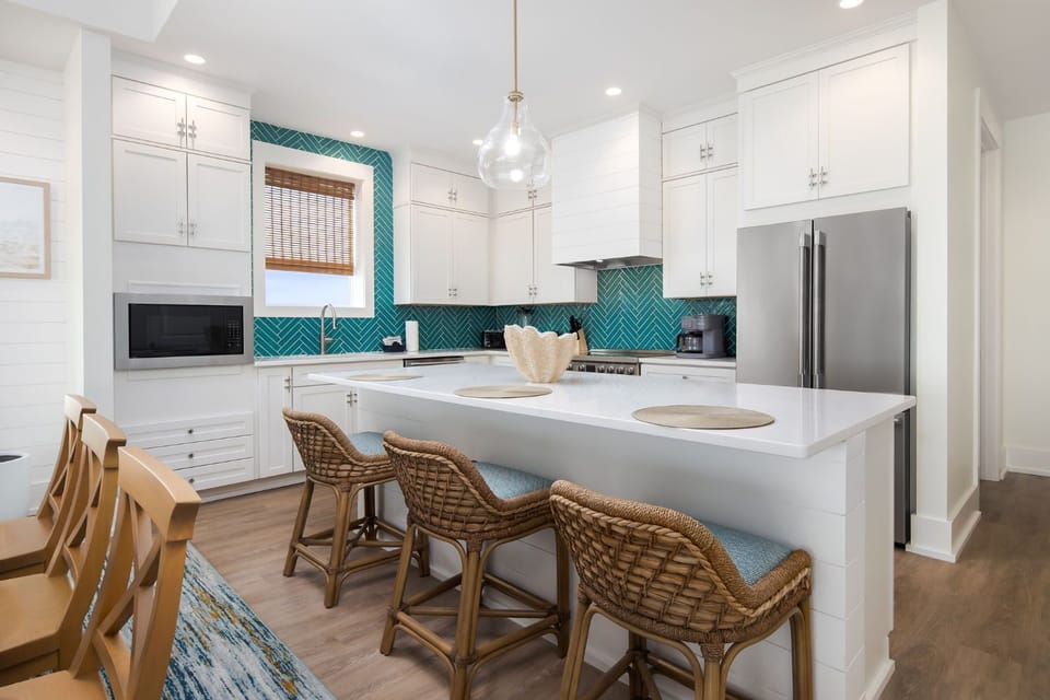 This coastal-inspired kitchen features vibrant teal backsplash and a spacious island perfect for gatherings.