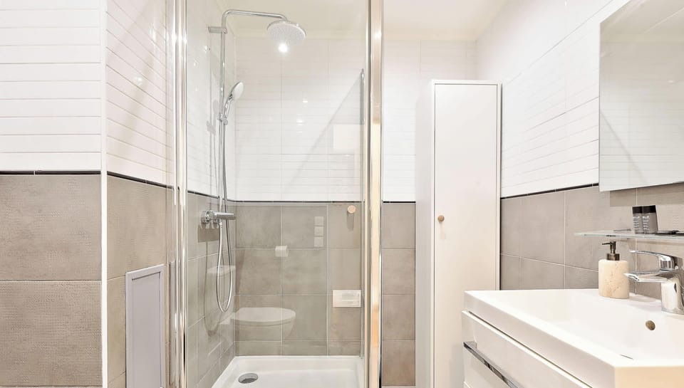 Salle de bain avec douche, lavabo, miroir et WC
