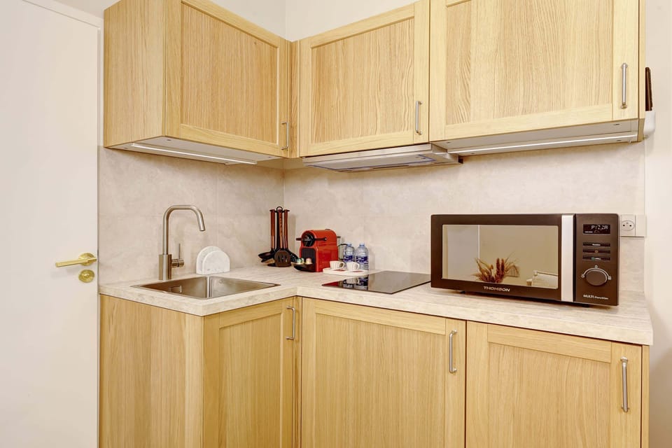 La pièce principale est lumineuse et ouverte, avec une kitchenette équipée, incluant un micro-ondes, une plaque de cuisson ainsi qu'une machine à café pour plus de praticité.