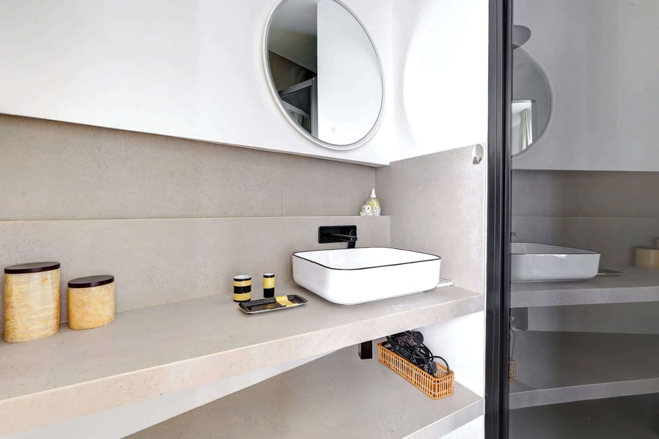 Salle de bain : douche, évier, lavabo, miroir et toilette.