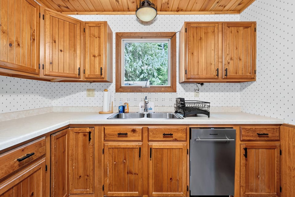 Above the stainless steel sink, there is a window to let in natural light.