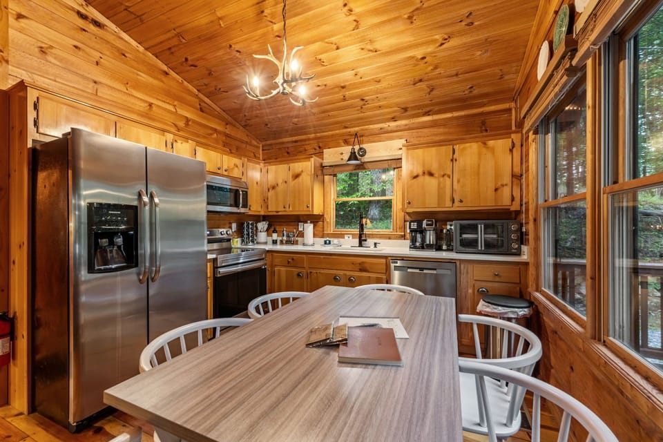 Rustic cabin kitchen with stainless appliances & forest views