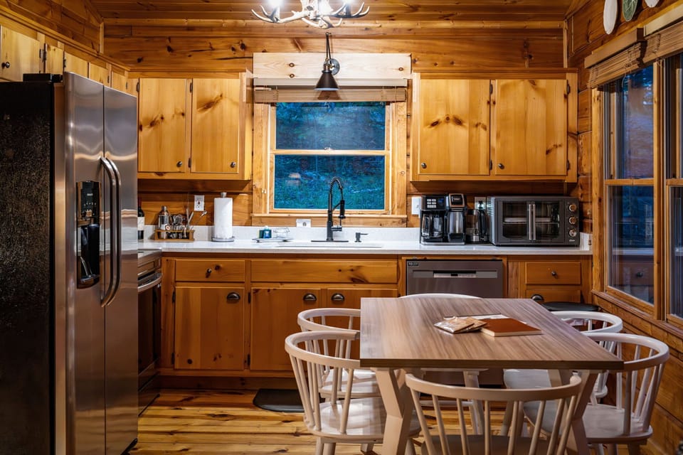 Cozy cabin kitchen with coffee bar, stainless appliances, and dining nook.