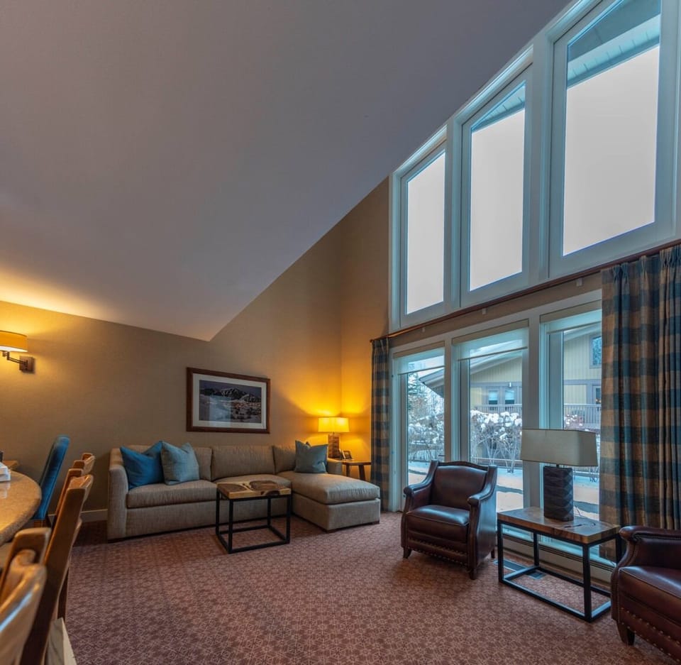 Relax beneath soaring windows with cozy evening lighting.