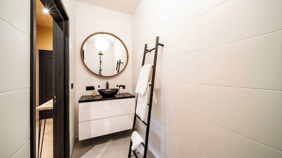 Modern bathroom with walk-in shower and stylish vanity. Clean and well maintained.