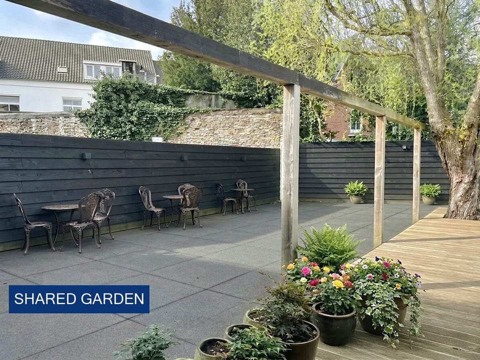 Ontspannende gedeelde tuin achter een stijlvol appartement in Breda, perfect om buiten te zitten en van de frisse lucht te genieten.