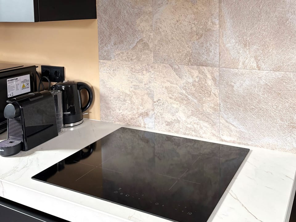 Modern induction stove for quick, safe, and energy-efficient cooking during your stay.