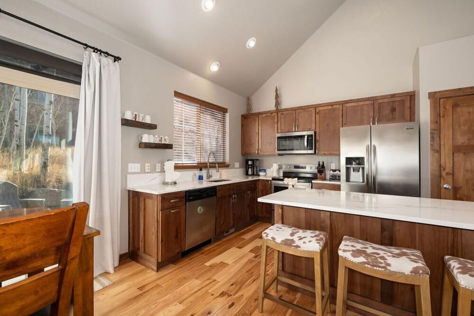 Step into your fully equipped kitchen with gleaming countertops, stainless steel appliances, and a breakfast bar perfect for morning coffee together.