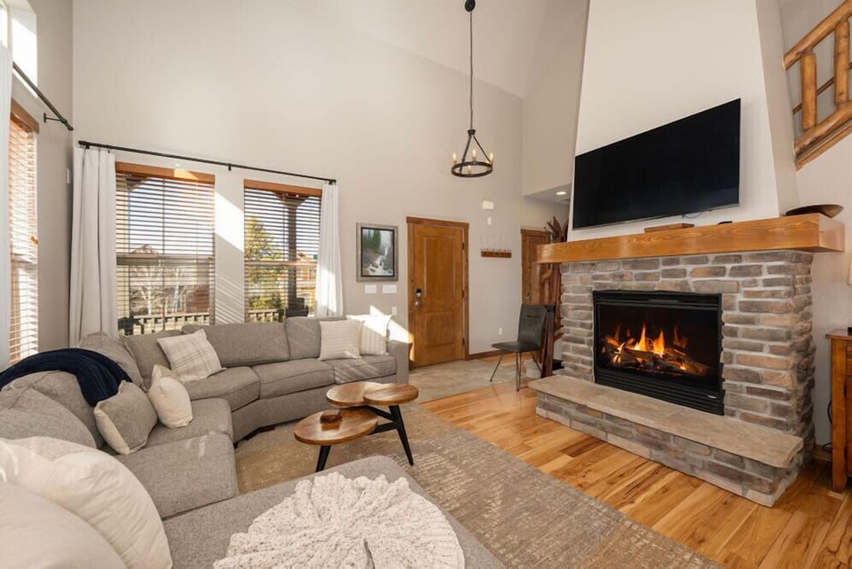 Sink into cozy sectional seating by your crackling fireplace, where warm flames and mountain views create the perfect retreat.