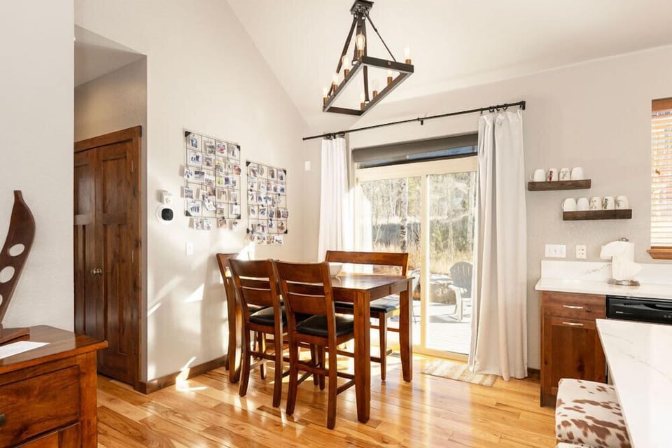 Your bright dining space features a warm wooden table where you'll enjoy meals bathed in natural light from the patio doors.