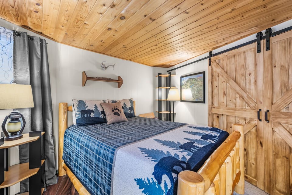 Drift off beneath rustic wood beams in your cozy bear-themed bedroom, where mountain charm meets comfort in every detail.