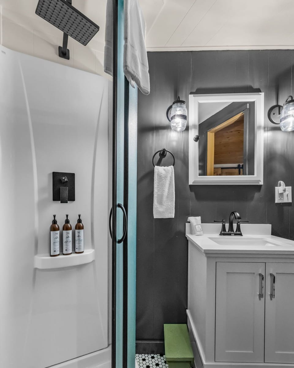 Your stylish bathroom features a rainfall shower, premium toiletries, and modern vanity with soft lighting.