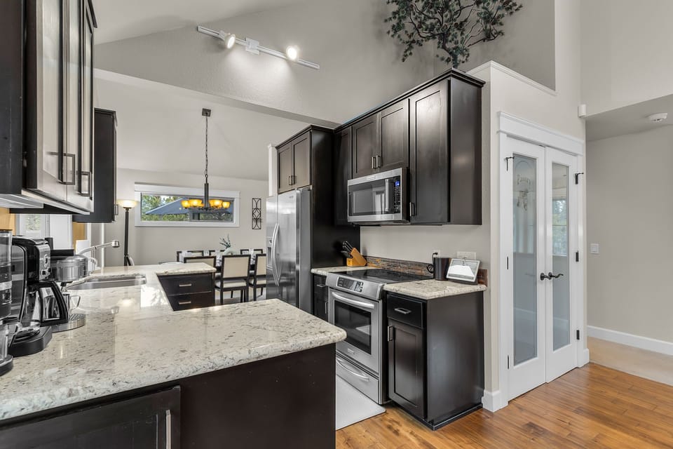 Your gourmet kitchen awaits with granite countertops, stainless steel appliances, and rich dark cabinetry for memorable meal preparation.