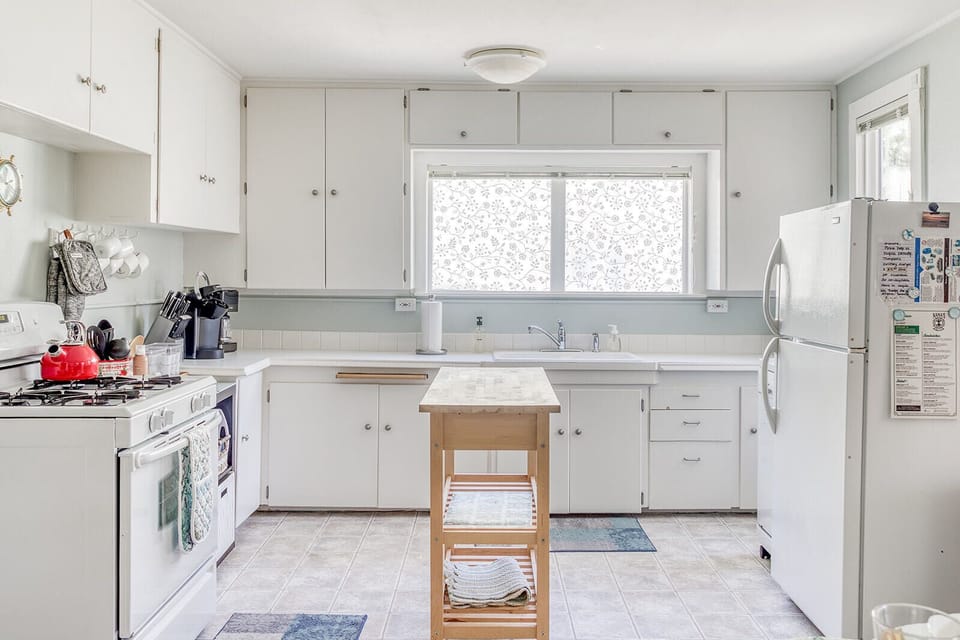Your fully equipped kitchen invites home-cooked meals with ample counter space, modern appliances, and a charming rolling cart for extra prep room.