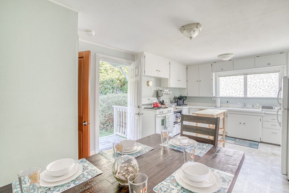 Gather around this sun-filled kitchen where your morning coffee tastes better and dinner conversations flow naturally at the farmhouse table.