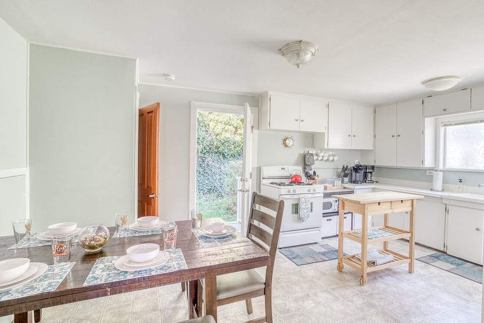 Your bright, fully-equipped kitchen welcomes you with white cabinets, modern appliances, and a charming dining table where you can enjoy meals together.