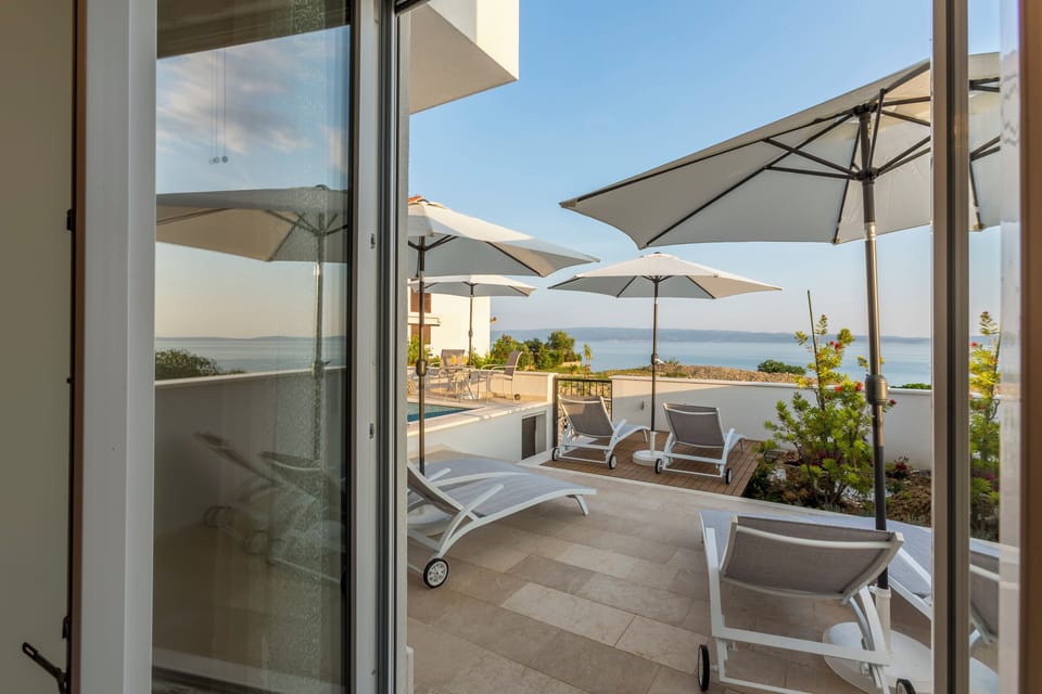 Outdoor pool with sun loungers during daytime.