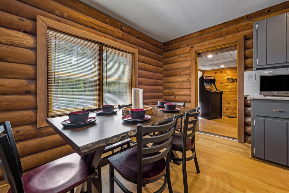 Gather around your rustic dining table where warm log walls create the perfect backdrop for memorable meals together.