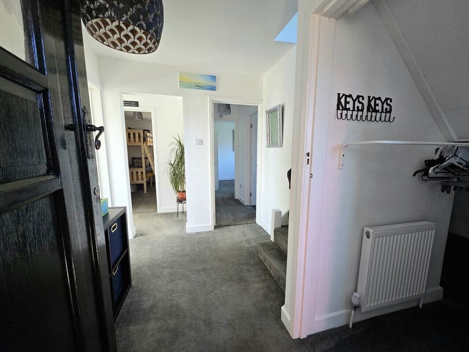 An entrance hall with a radiator, wall hooks, and a “KEYS KEYS” wall sign.